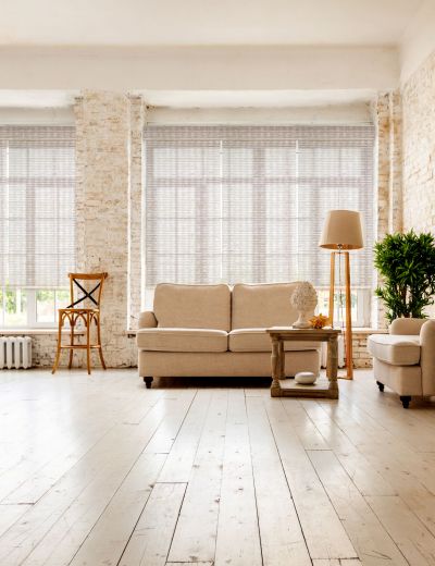 Large spacious room with a trendy loft design of sitting area. huge windows and stylish wicker light furniture inside. an abundance of ethnic decor